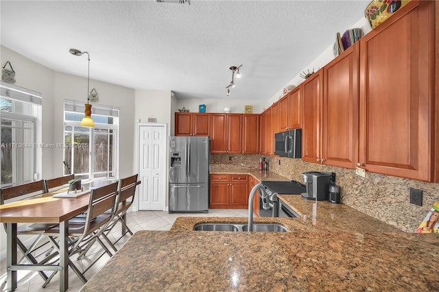 kitchen with pendant lighting, sink, decorative backsplash, light tile patterned floors, and stainless steel appliances