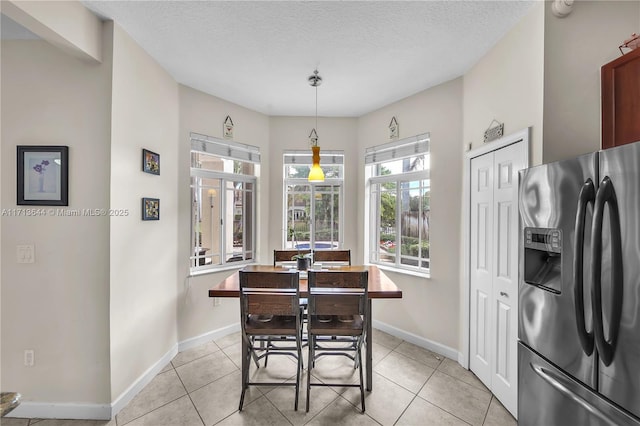 tiled dining area with a textured ceiling