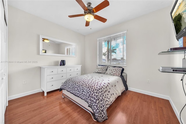 bedroom featuring light wood-style flooring, baseboards, and a ceiling fan