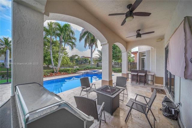 view of patio with a fenced backyard, an outdoor fire pit, a ceiling fan, and a pool with connected hot tub