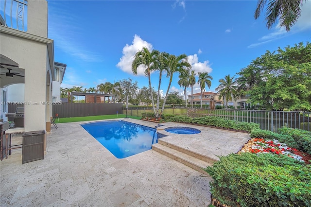view of pool with a fenced backyard, a ceiling fan, a patio, and a pool with connected hot tub