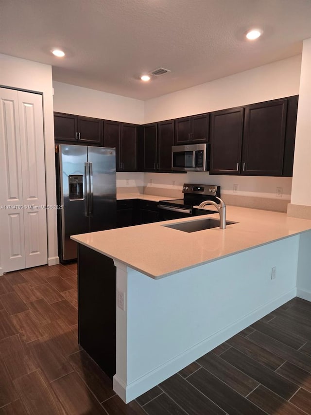 kitchen with kitchen peninsula, sink, and appliances with stainless steel finishes