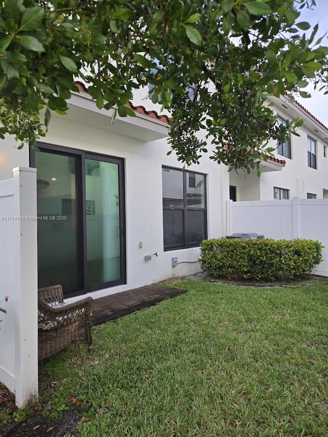 rear view of property featuring a lawn