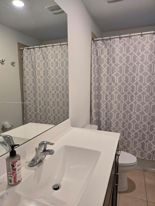 bathroom with tile patterned floors, walk in shower, vanity, and toilet