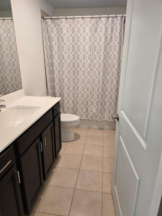 bathroom with tile patterned flooring, vanity, and toilet