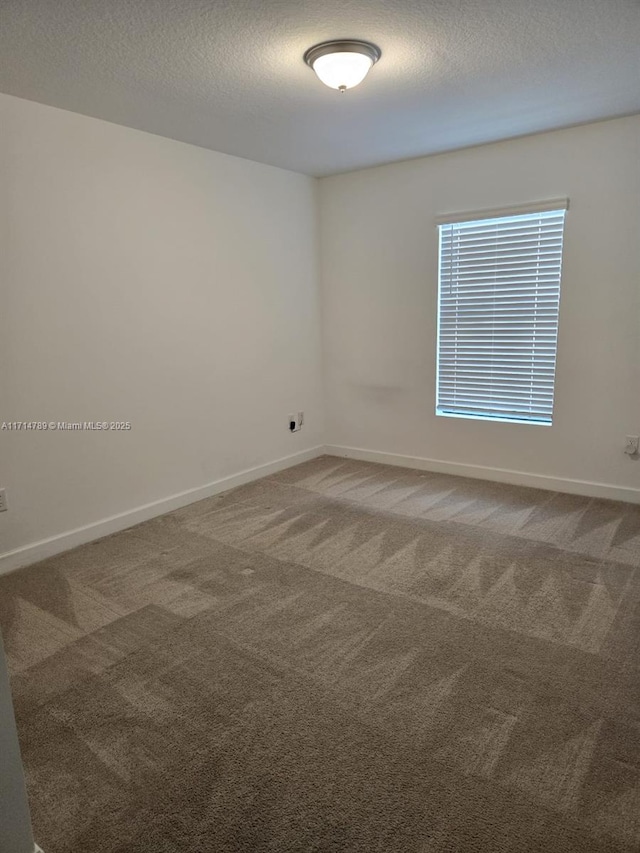 spare room with a textured ceiling and carpet floors