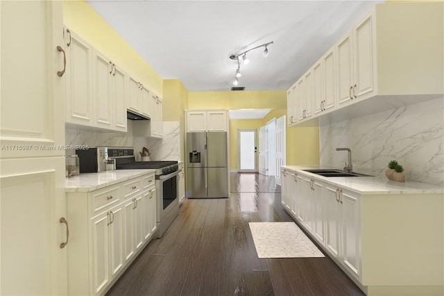 kitchen featuring white cabinets, decorative backsplash, sink, and appliances with stainless steel finishes