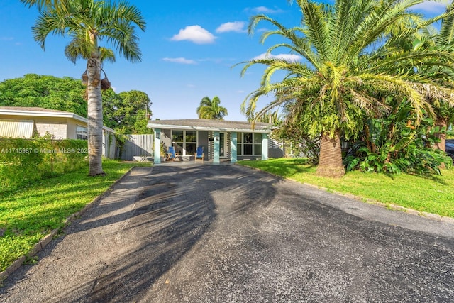 ranch-style home with covered porch and a front lawn