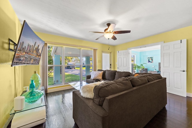 living room with ceiling fan and dark hardwood / wood-style flooring