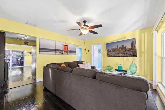 living room with dark hardwood / wood-style flooring and ceiling fan