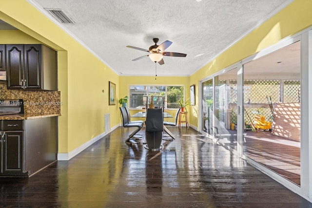 dining space featuring a textured ceiling, ceiling fan, crown molding, and dark hardwood / wood-style floors