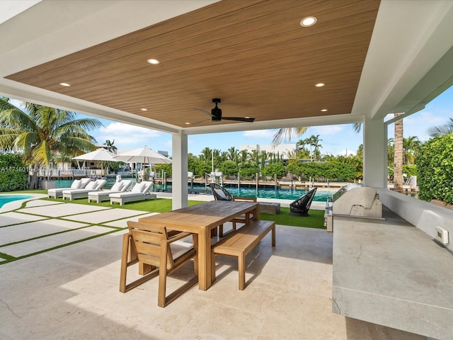 view of patio featuring an outdoor kitchen, ceiling fan, and a water view