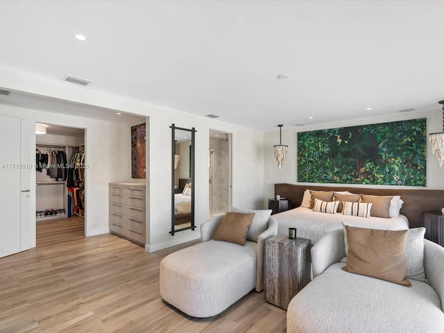 bedroom featuring light wood-type flooring, a spacious closet, and a closet