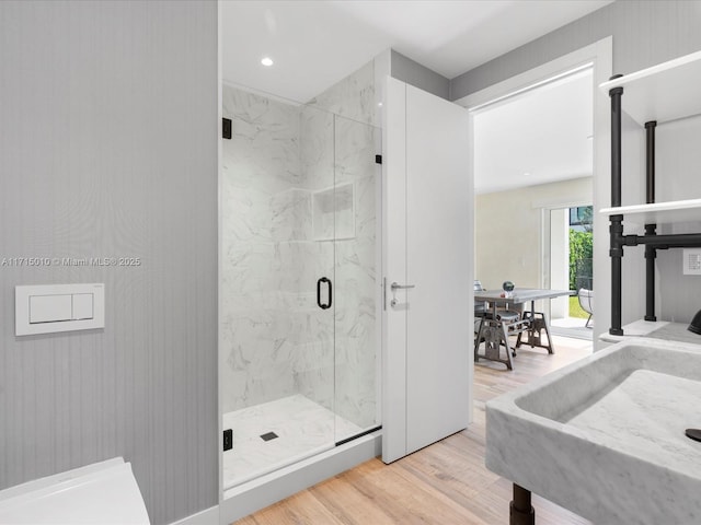 bathroom featuring wood-type flooring and a shower with door