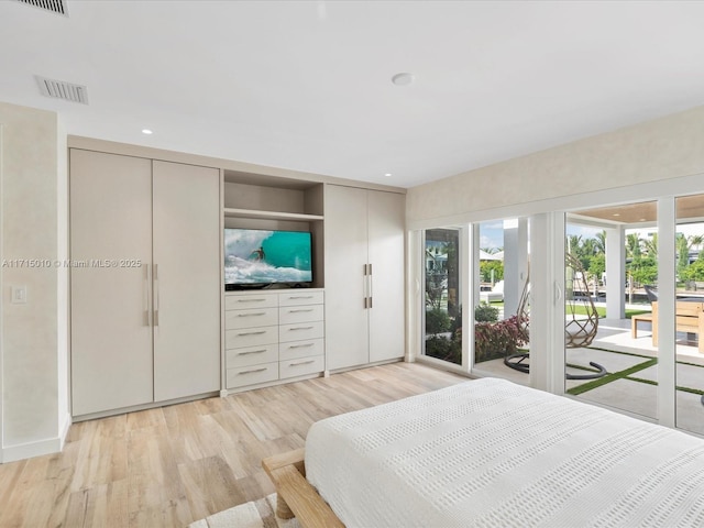 bedroom with access to exterior and light hardwood / wood-style floors