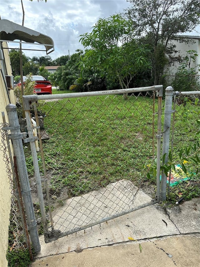 view of gate featuring a yard