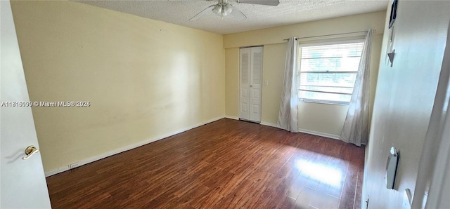 spare room featuring ceiling fan, dark hardwood / wood-style flooring, and a textured ceiling