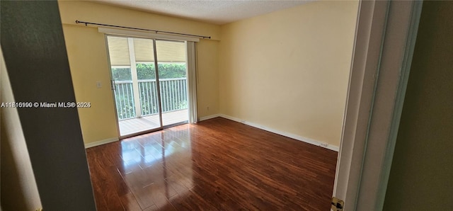 unfurnished room with dark hardwood / wood-style flooring and a textured ceiling