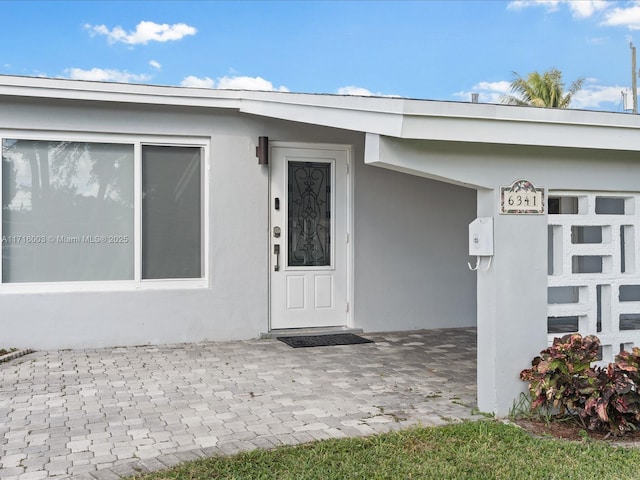 view of exterior entry with a patio