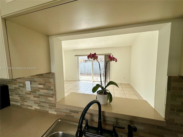 kitchen featuring light tile patterned flooring, sink, and backsplash