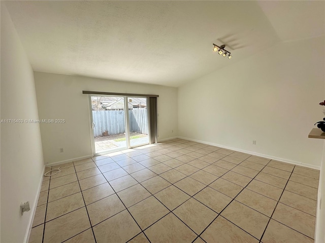 unfurnished room featuring a textured ceiling and light tile patterned floors