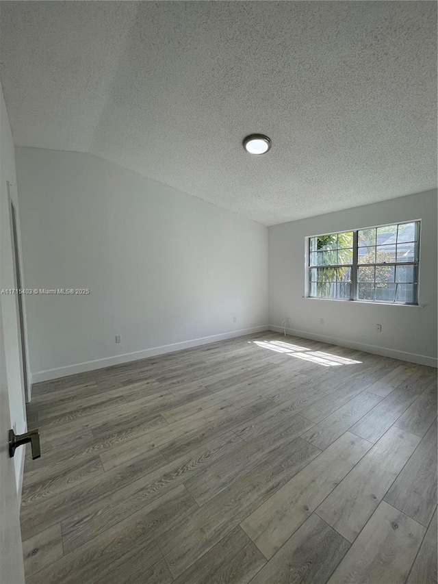 spare room featuring hardwood / wood-style flooring and a textured ceiling