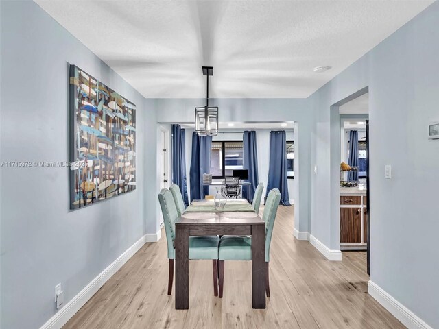 6708 NW 58th Ct, Tamarac, FL 33321 - dining space featuring an inviting chandelier, a textured ceiling, and light hardwood / wood-style flooring