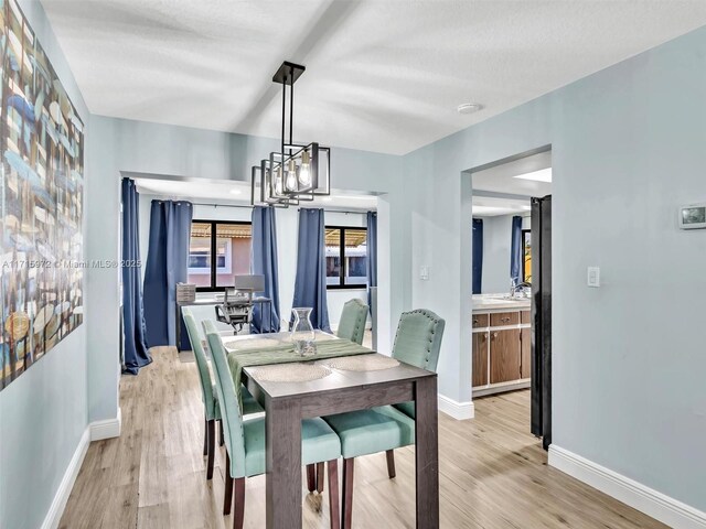 6708 NW 58th Ct, Tamarac, FL 33321 - dining area with light wood-type flooring and an inviting chandelier