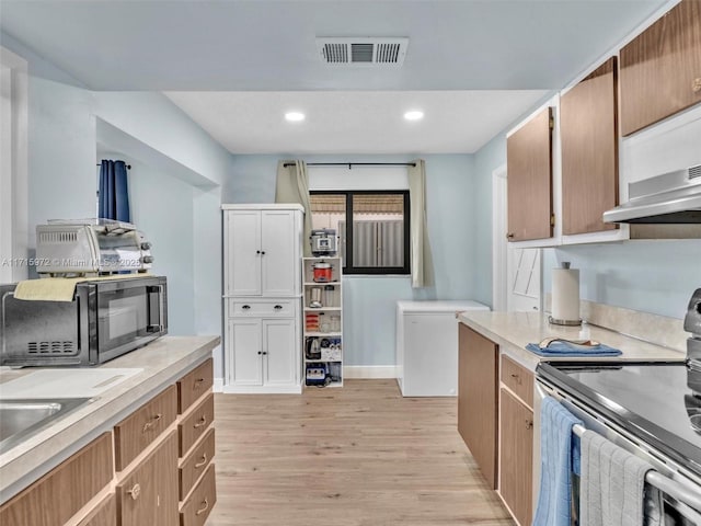 kitchen featuring light wood-type flooring and stainless steel electric range