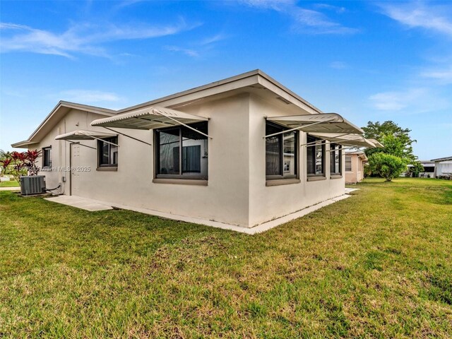 6708 NW 58th Ct, Tamarac, FL 33321 - view of side of home with a yard and central air condition unit