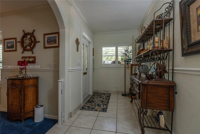 interior space with light tile patterned flooring, a textured ceiling, and ornamental molding