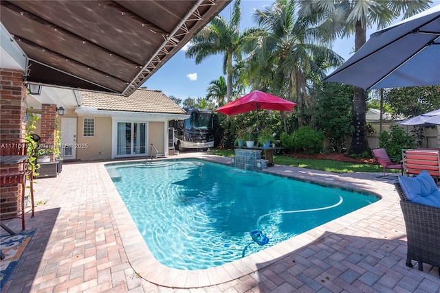 view of swimming pool with a patio area and a trampoline