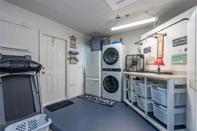 clothes washing area featuring a textured ceiling and stacked washer and clothes dryer