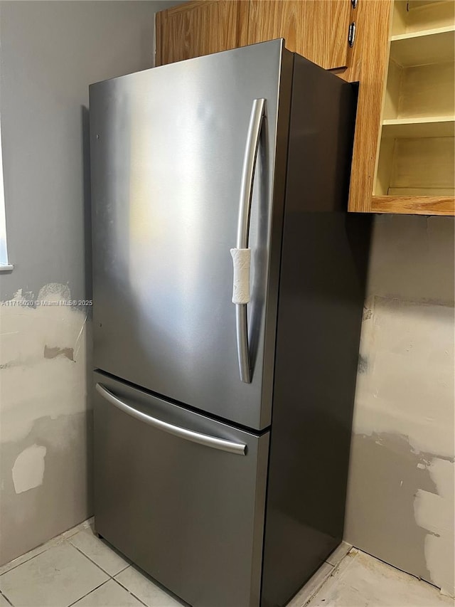 kitchen featuring light tile patterned flooring and stainless steel fridge