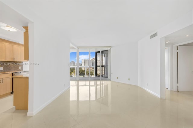 unfurnished living room with expansive windows and light tile patterned floors