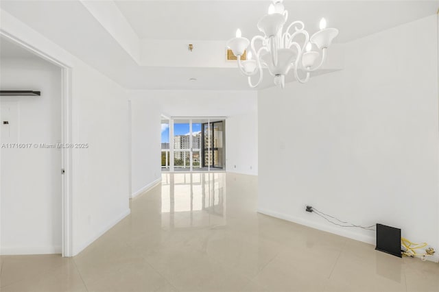 empty room featuring tile patterned floors and an inviting chandelier