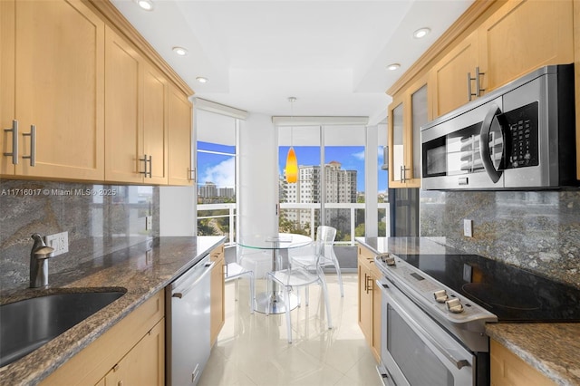 kitchen featuring hanging light fixtures, sink, appliances with stainless steel finishes, tasteful backsplash, and light tile patterned flooring