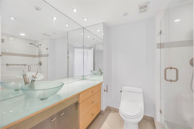 bathroom featuring tile patterned floors, vanity, toilet, and walk in shower