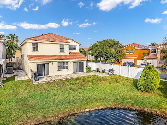 rear view of house featuring cooling unit, a tiled roof, a lawn, stucco siding, and a fenced backyard