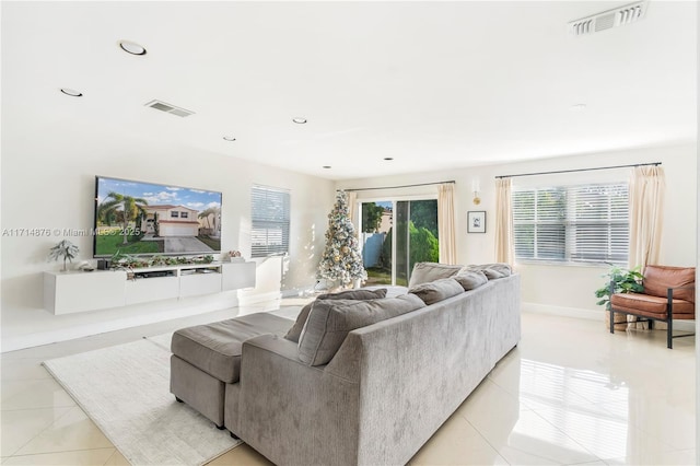 living area with light tile patterned floors, visible vents, recessed lighting, and baseboards