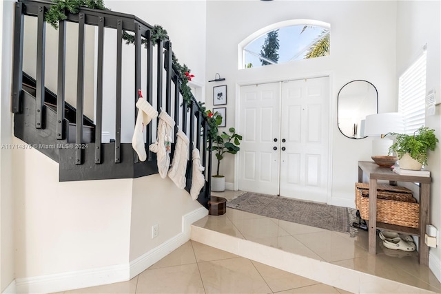 foyer entrance with tile patterned flooring and a high ceiling