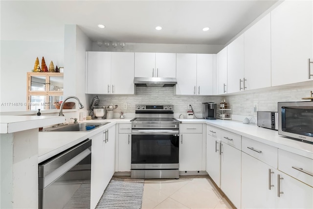 kitchen featuring stainless steel appliances, under cabinet range hood, light countertops, and a sink