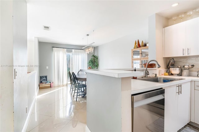 kitchen with kitchen peninsula, sink, pendant lighting, light tile patterned floors, and white cabinetry