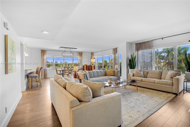 living room with a chandelier and light wood-type flooring