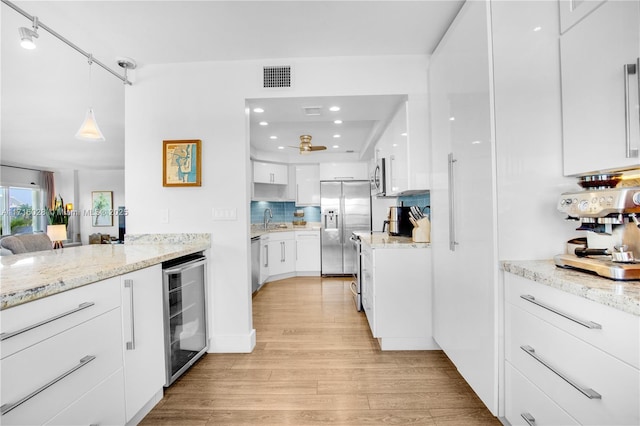 kitchen with white cabinetry, light stone countertops, stainless steel appliances, beverage cooler, and pendant lighting