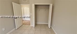 unfurnished bedroom featuring light tile patterned floors and a closet