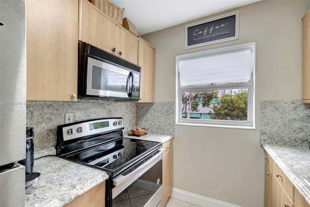 kitchen featuring decorative backsplash, appliances with stainless steel finishes, light brown cabinets, light tile patterned floors, and light stone counters