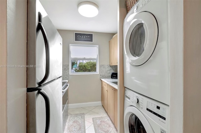 clothes washing area featuring stacked washer / drying machine and light tile patterned floors