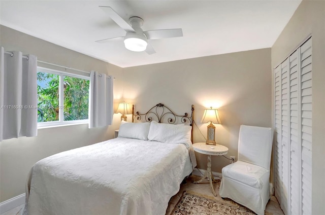 tiled bedroom with ceiling fan and a closet