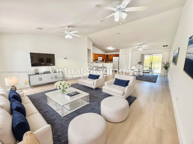 living room with vaulted ceiling and light hardwood / wood-style flooring